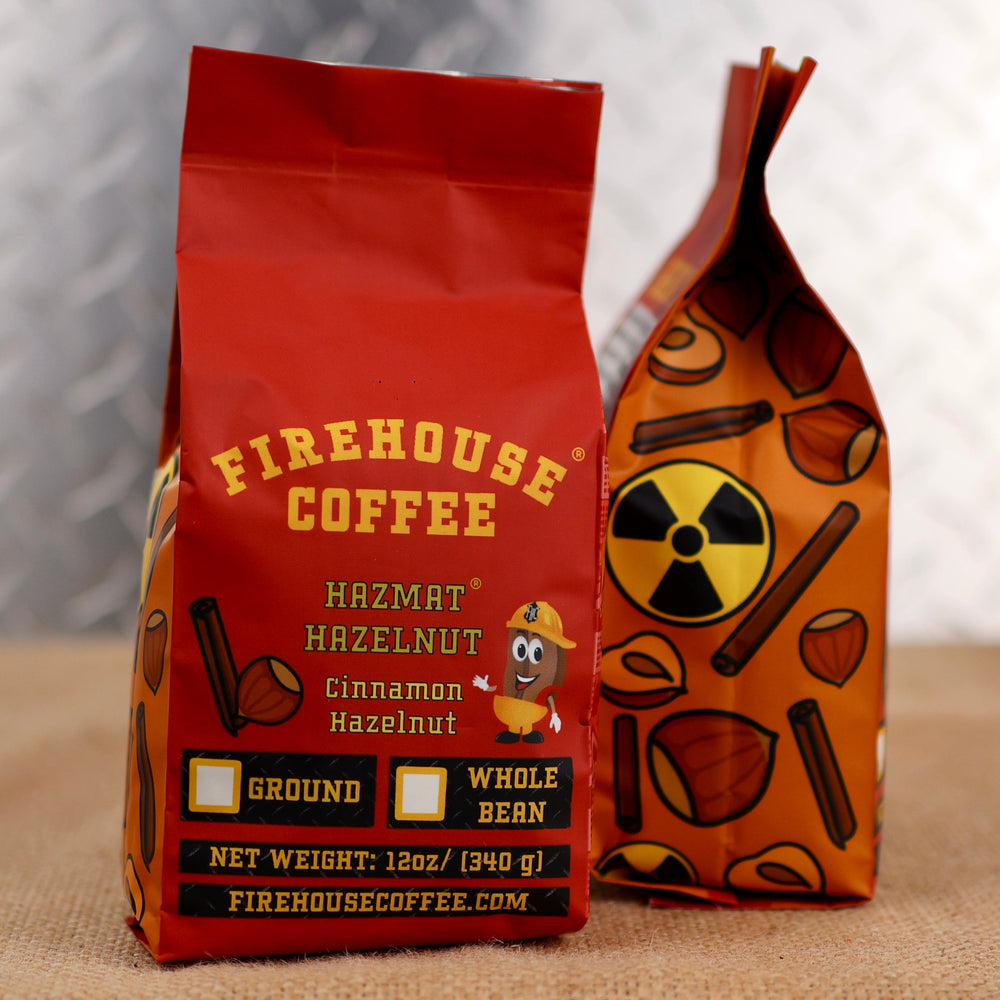 Firehouse Coffee Hazmat Hazelnut Cinnamon Hazelnut 12oz coffee bags, shown in ground and whole bean packaging with red front bag and orange hazard-patterned side bag