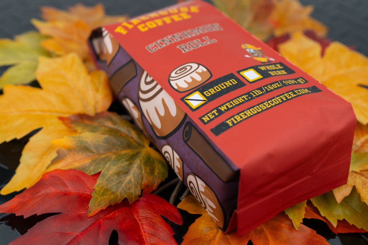 Firehouse Coffee Cinnamon Roll coffee bag surrounded by autumn leaves