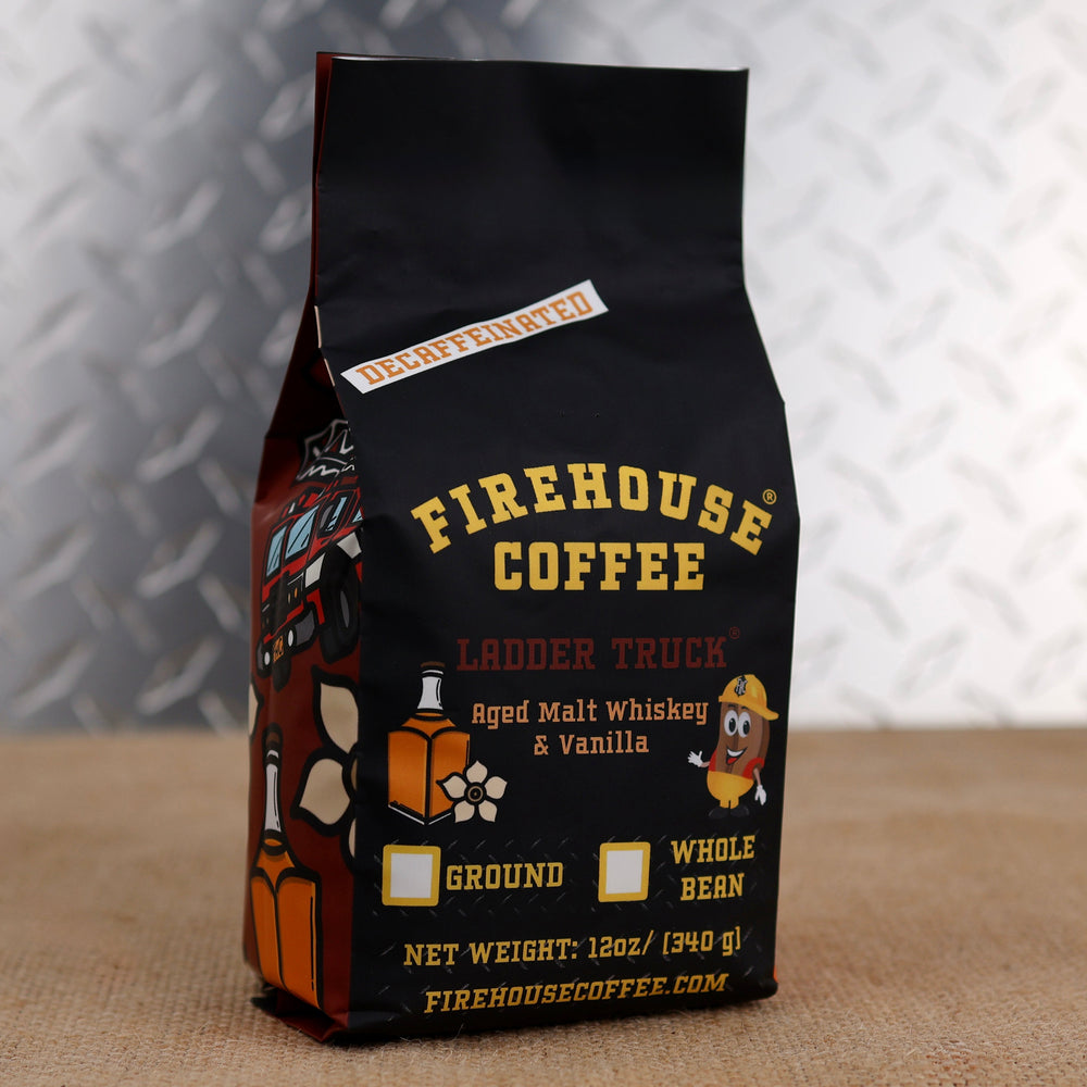 Firehouse Coffee Ladder Truck Decaf flavored coffee in a 12 oz bag featuring aged malt whiskey and vanilla flavors. Premium decaffeinated coffee available in whole bean or ground, with Firehouse Coffee branding and firefighter-themed packaging.