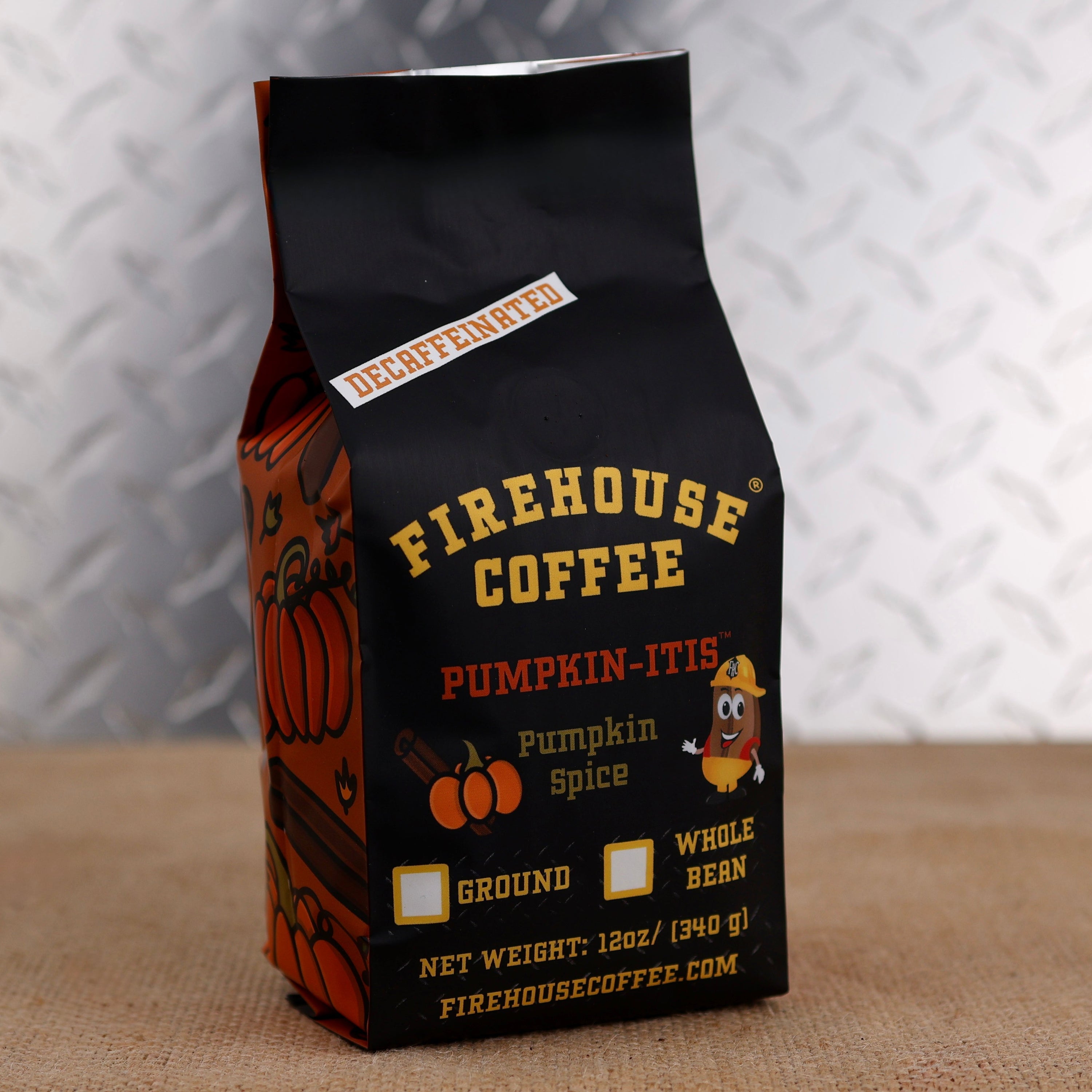 Firehouse Coffee Pumpkin-Itis Decaffeinated Pumpkin Spice flavored coffee in a 12 oz bag with festive pumpkin artwork. Swiss Water Process decaf coffee available ground or whole bean, delivering warm pumpkin spice flavor in a smooth medium roast.
