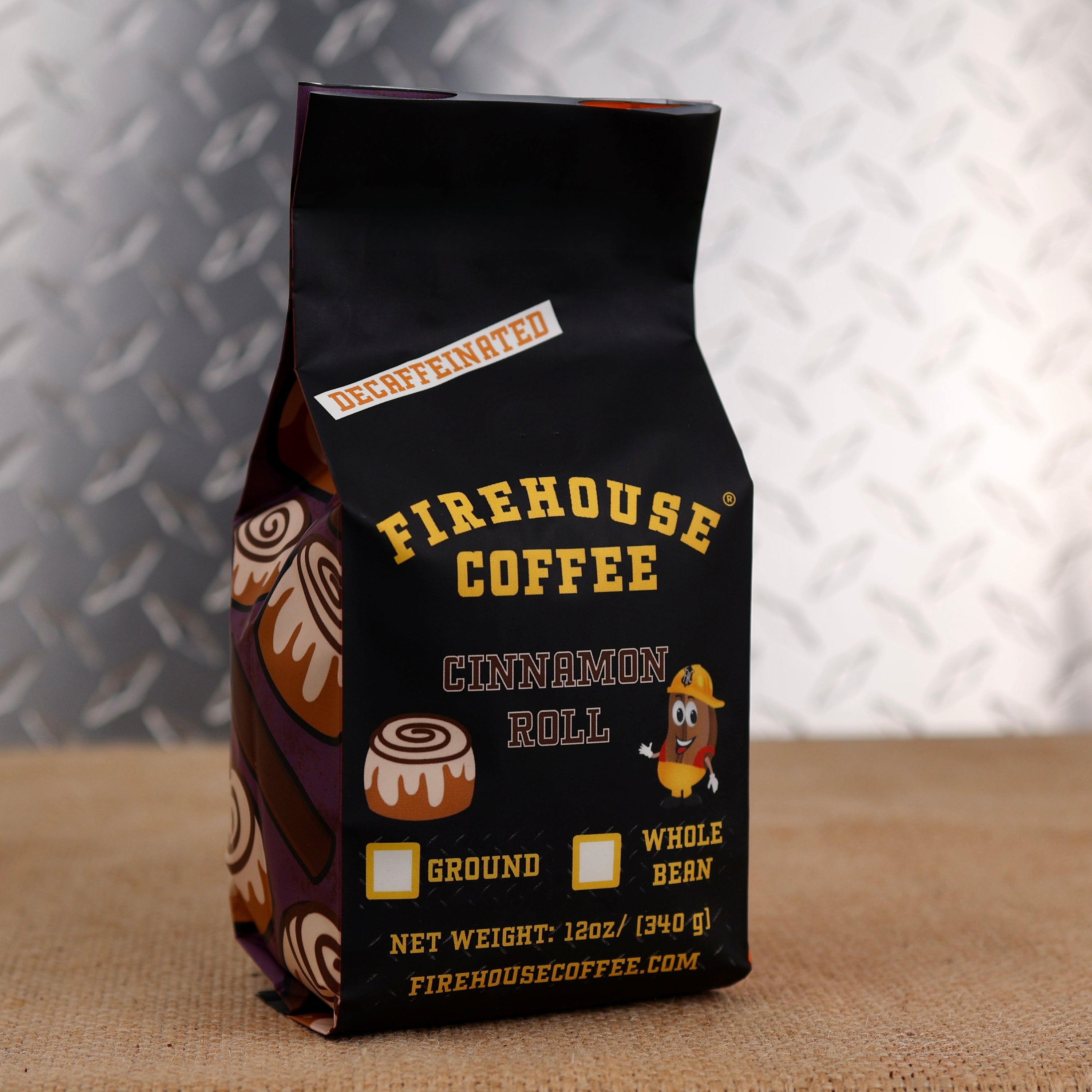 12oz bag of Firehouse Coffee Decaf Cinnamon Roll flavored coffee featuring bakery-inspired packaging, Swiss Water Process decaf coffee with sweet cinnamon roll and vanilla icing flavor.