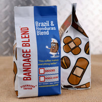 Two coffee bags with 'Bandage Blend' branding.  Bag looks like a box of bandaids. 