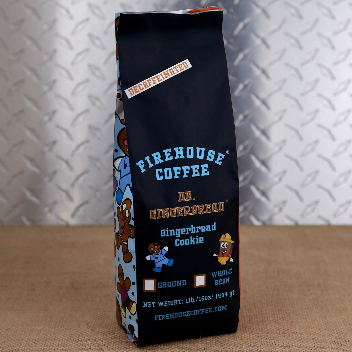 Firehouse Coffee Dr. Gingerbread Gingerbread Cookie Decaffeinated 1lb coffee bag with gingerbread first responder characters on light blue side panels, front view on a textured surface.