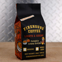 Firehouse Coffee Lights & Sirens Decaffeinated Pumpkin Crème Brûlée flavored coffee in a 12 oz bag featuring festive fall pumpkin artwork. Swiss Water Process decaf coffee with rich pumpkin, caramelized sugar, and creamy crème brûlée flavor, available ground or whole bean.