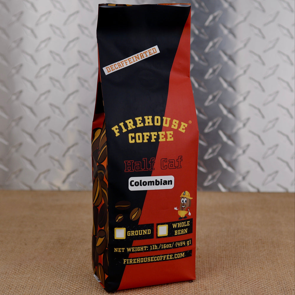 A bag of Firehouse Coffee Colombian Half Caf whole bean coffee, standing upright on a burlap surface against a diamond plate metal background.